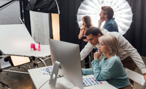 selective focus of coworkers looking at computer monitor in photo studio